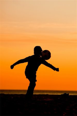 simsearch:400-07554888,k - Young boy having fun on the beach playing football Foto de stock - Super Valor sin royalties y Suscripción, Código: 400-04721568