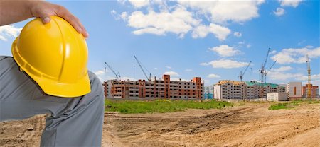 simsearch:400-07716868,k - Closeup of yellow helmet at builder hands on building background Stock Photo - Budget Royalty-Free & Subscription, Code: 400-04723815