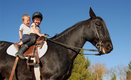 two happy children on their black stallion Stock Photo - Budget Royalty-Free & Subscription, Code: 400-04734529