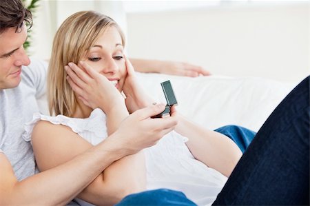 young man proposing to his surprised girlfriend lying on the sofa at home Stock Photo - Budget Royalty-Free & Subscription, Code: 400-04734912