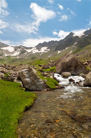 simsearch:400-04734960,k - A stream with green grass banks of the mountains in the background. Foto de stock - Royalty-Free Super Valor e Assinatura, Número: 400-04734960