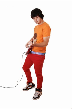 simsearch:693-06380087,k - A teenage boy standing and playing the guitar in red jeans and a orange  sweater and black short hair, on a white background. Photographie de stock - Aubaine LD & Abonnement, Code: 400-04735043