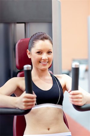 simsearch:400-04256139,k - beautiful athletic woman using a bench press smiling at the camera in a fitness center Stock Photo - Budget Royalty-Free & Subscription, Code: 400-04735416