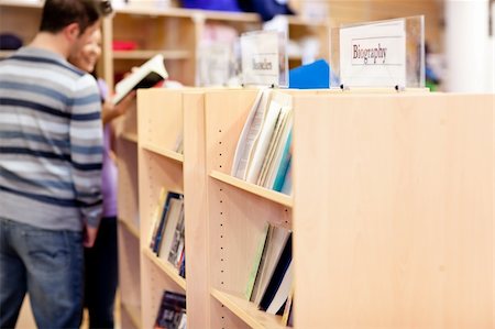 simsearch:400-04295114,k - close-up of a bookshelves in a library with students reading  standing in the background Photographie de stock - Aubaine LD & Abonnement, Code: 400-04735424