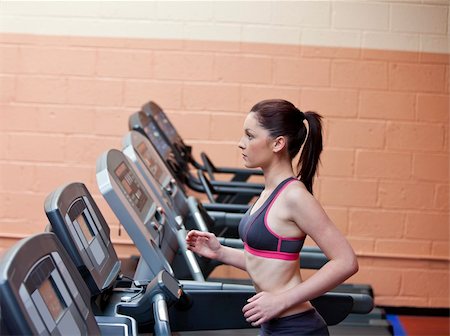 Serious female athlete doing exercises on a treadmill in a fitness centre Foto de stock - Super Valor sin royalties y Suscripción, Código: 400-04735436