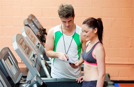 simsearch:400-04256139,k - Serious coach giving instruction to a female athlete standing on a treadmill in a fitness centre Stock Photo - Budget Royalty-Free & Subscription, Code: 400-04735433