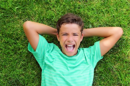 boy laughing happy teenager laying green grass Photographie de stock - Aubaine LD & Abonnement, Code: 400-04736367