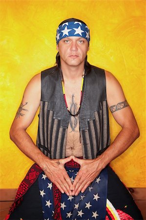 simsearch:400-04732676,k - Kneeling Native American man with tattoos and vest Foto de stock - Royalty-Free Super Valor e Assinatura, Número: 400-04736582