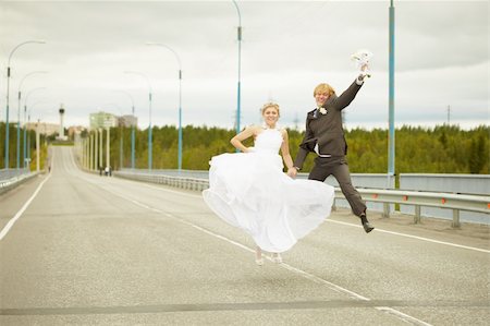 Newly married young pair cheerfully jumps on highway Stock Photo - Budget Royalty-Free & Subscription, Code: 400-04737218