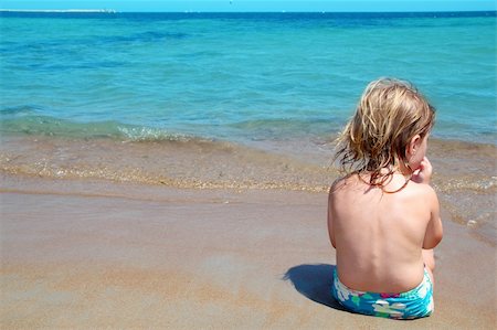 simsearch:400-04596901,k - Little blond girl sit in beach shore looking turquoise ocean Stock Photo - Budget Royalty-Free & Subscription, Code: 400-04738462