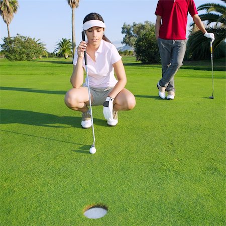 playing golf young woman looking and aiming for the hole Stock Photo - Budget Royalty-Free & Subscription, Code: 400-04738471