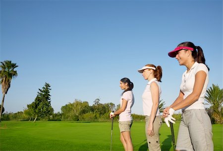 simsearch:400-04319321,k - Golf three woman in a row green grass course players Photographie de stock - Aubaine LD & Abonnement, Code: 400-04738472
