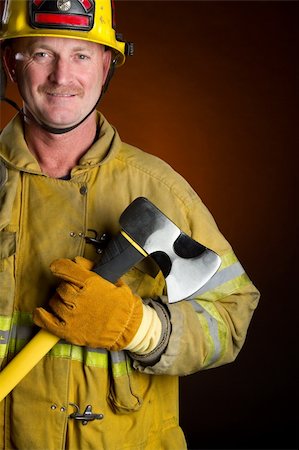 simsearch:400-06392786,k - Smiling firefighter holding axe Fotografie stock - Microstock e Abbonamento, Codice: 400-04739533