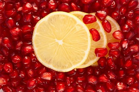 simsearch:693-08127360,k - Lemon slices on pomegranate seeds background Photographie de stock - Aubaine LD & Abonnement, Code: 400-04739559