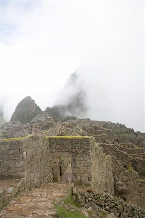 Machu Picchu is a pre-Columbian Inca site located 2,430 metres (8,000 ft) above sea level. It is situated on a mountain ridge above the Urubamba Valley in Peru, which is 80 kilometres (50 mi) northwest of Cusco and through which the Urubamba River flows. The river is a partially navigable headwater of the Amazon River. Often referred to as "The Lost City of the Incas", Machu Picchu is one of the m Foto de stock - Super Valor sin royalties y Suscripción, Código: 400-04731917