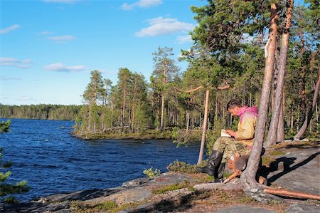 simsearch:400-04804407,k - The tourist reading the book on rocky coast of blue lake Stock Photo - Budget Royalty-Free & Subscription, Code: 400-04732189