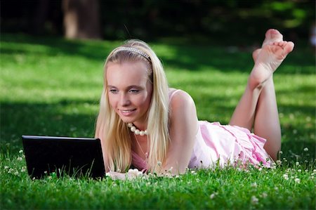 Young woman lying on grass in park and using laptop Stock Photo - Budget Royalty-Free & Subscription, Code: 400-04732212