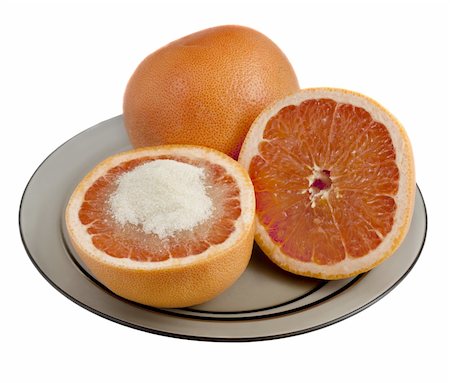 simsearch:693-06020240,k - red grapefruit cut and served with cane sugar on a glass plate, isolated on white Photographie de stock - Aubaine LD & Abonnement, Code: 400-04732620
