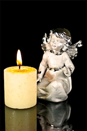 Christmas Angel staring at a burning candle. Fotografie stock - Microstock e Abbonamento, Codice: 400-04745245