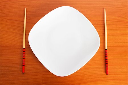 simsearch:400-05297094,k - Plate with chopsticks on the wooden table Fotografie stock - Microstock e Abbonamento, Codice: 400-04748256