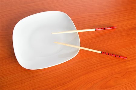 simsearch:400-05297094,k - Plate with chopsticks on the wooden table Fotografie stock - Microstock e Abbonamento, Codice: 400-04748251
