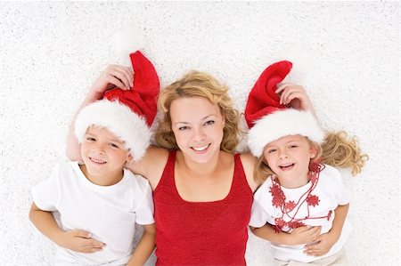 simsearch:400-05008640,k - Woman and kids lating on the floor at christmas time wearing santa hats Photographie de stock - Aubaine LD & Abonnement, Code: 400-04740139