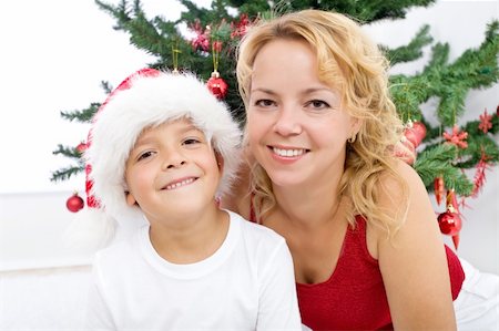 simsearch:400-05008640,k - Happy woman and little boy christmas portrait by the decorated tree - high key Photographie de stock - Aubaine LD & Abonnement, Code: 400-04740140