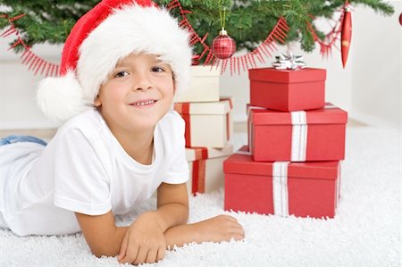 simsearch:400-07332398,k - Happy boy with lots of christmas presents laying under the decorated tree Photographie de stock - Aubaine LD & Abonnement, Code: 400-04740141