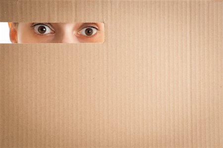 surprised woman eyes looking through the hole in cardboard Fotografie stock - Microstock e Abbonamento, Codice: 400-04743948