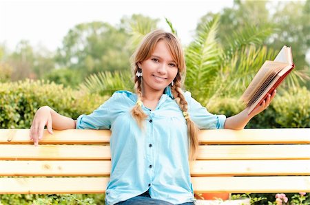 beautiful young student girl sitting on bench in campus park, reading book and smiling and looking into the camera Stock Photo - Budget Royalty-Free & Subscription, Code: 400-04743962