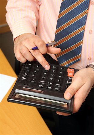 simsearch:640-01362673,k - businessman counts money on calculator - close-up view Stock Photo - Budget Royalty-Free & Subscription, Code: 400-04754677