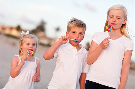 family eating on the beach - Cute Brother and Sisters Enjoying Their Lollipops at the Beach. Stock Photo - Budget Royalty-Free & Subscription, Code: 400-04756073