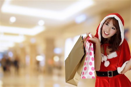 Happy shopping girl wearing Christmas clothes holding bags in department store. Stock Photo - Budget Royalty-Free & Subscription, Code: 400-04756789