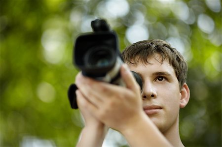 filmproduzent (männlich und weiblich) - teen with camcorder capturing, selective focus on eye, natural light Stockbilder - Microstock & Abonnement, Bildnummer: 400-04756820