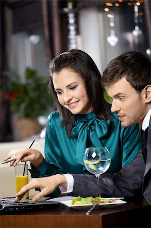 Young woman and the man discuss something on the laptop screen in cafe Stock Photo - Budget Royalty-Free & Subscription, Code: 400-04756922