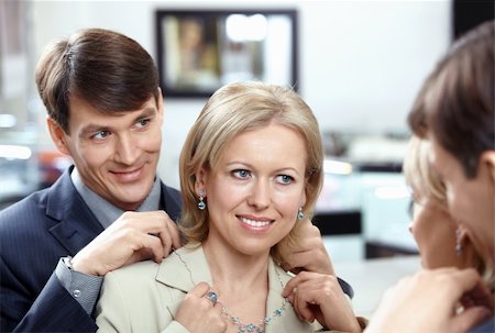 simsearch:400-04778993,k - The woman tries on a necklace at a mirror in shop Stock Photo - Budget Royalty-Free & Subscription, Code: 400-04756940