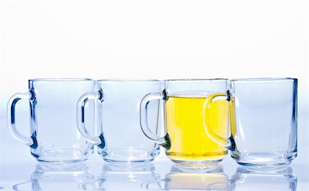 segregation - four glass cups three of which are empty and one with a yellow tea Stock Photo - Budget Royalty-Free & Subscription, Code: 400-04757287