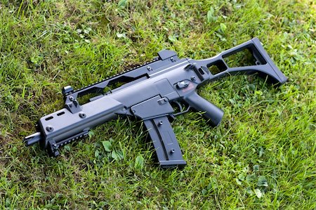 Black automatic rifle on the ground in grass. Photographie de stock - Aubaine LD & Abonnement, Code: 400-04757552