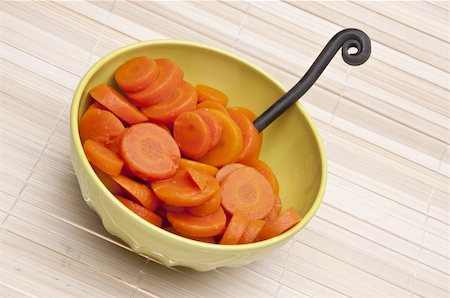 simsearch:400-04300921,k - Bowl of canned carrots with fork on a bamboo mat background. Photographie de stock - Aubaine LD & Abonnement, Code: 400-04757564