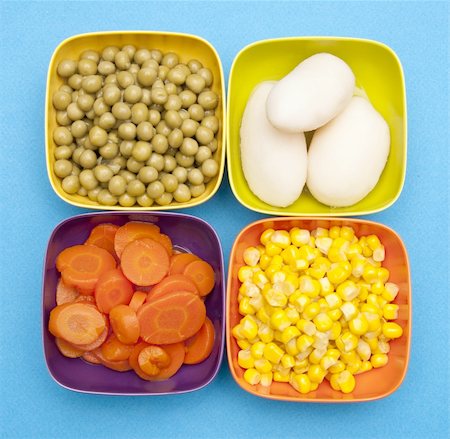 simsearch:400-04267736,k - Vibrant Canned Vegetables in Bright Bowls on a blue background including corn, peas, potatoes, and carrots. Fotografie stock - Microstock e Abbonamento, Codice: 400-04757605