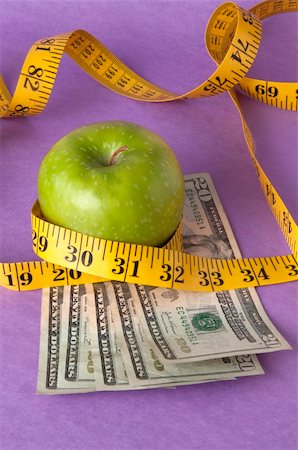 simsearch:400-04758612,k - An apple, tape measure, and American currency represents the concept of measuring the cost of healthcare, food, or education.  Can also work for concept of the cost of healthcare, education or food. Stock Photo - Budget Royalty-Free & Subscription, Code: 400-04758608