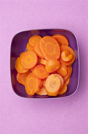 simsearch:400-04300921,k - Bowl of Canned Carrots on a Vibrant Purple Background. Photographie de stock - Aubaine LD & Abonnement, Code: 400-04759069