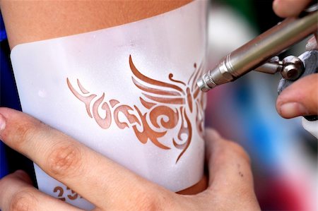 creating an air brush tattoo on a young girl's arm Stock Photo - Budget Royalty-Free & Subscription, Code: 400-04750104