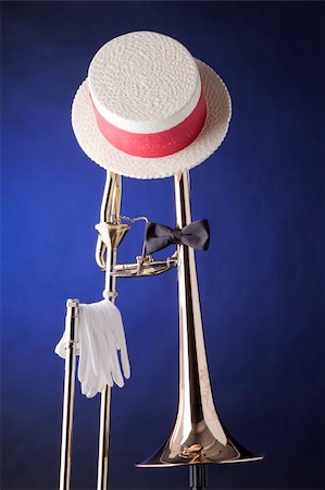 A professional trombone with hat, bow tie, and gloves, isolated against a spotlight blue background. Photographie de stock - Aubaine LD & Abonnement, Code: 400-04750919