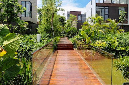 simsearch:400-04565056,k - Wooden footpath through a tranquil garden and two rows of new terrace houses beside it Photographie de stock - Aubaine LD & Abonnement, Code: 400-04751098