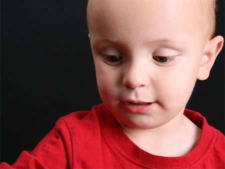 simsearch:400-05727835,k - Blond toddler against a black background with a serious expression Fotografie stock - Microstock e Abbonamento, Codice: 400-04751676