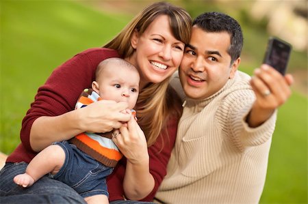 Happy Mixed Race Parents and Baby Boy Taking Self Portraits at the Park. Stock Photo - Budget Royalty-Free & Subscription, Code: 400-04751689