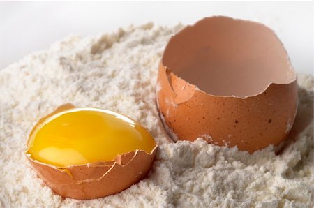 Broken eggshell and yolk in the flour macro shot Foto de stock - Royalty-Free Super Valor e Assinatura, Número: 400-04764961