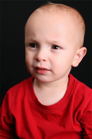 simsearch:400-05727835,k - Cute toddler wearing a red shirt with a frown Fotografie stock - Microstock e Abbonamento, Codice: 400-04765430