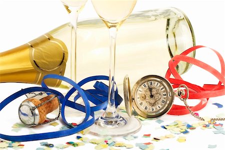 two glasses with champagne, old pocket watch, streamer, cork and confetti in front of a champagne bottle on white background Stock Photo - Budget Royalty-Free & Subscription, Code: 400-04766802